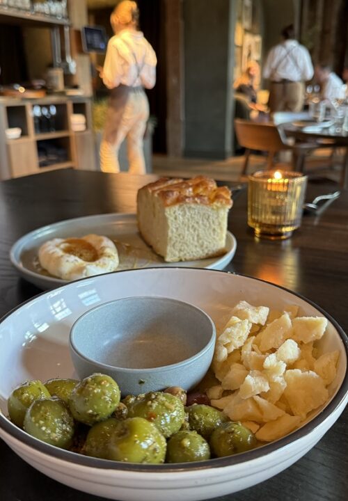Oven-warmed green olives tossed in herb salsa verde and paired with aged Parmesan—simple, briny bites that channel the flavors of coastal Italy.