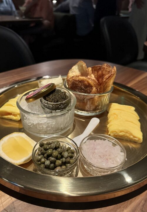 Delicate caviar served with classic accompaniments sets the tone for a luxurious meal.